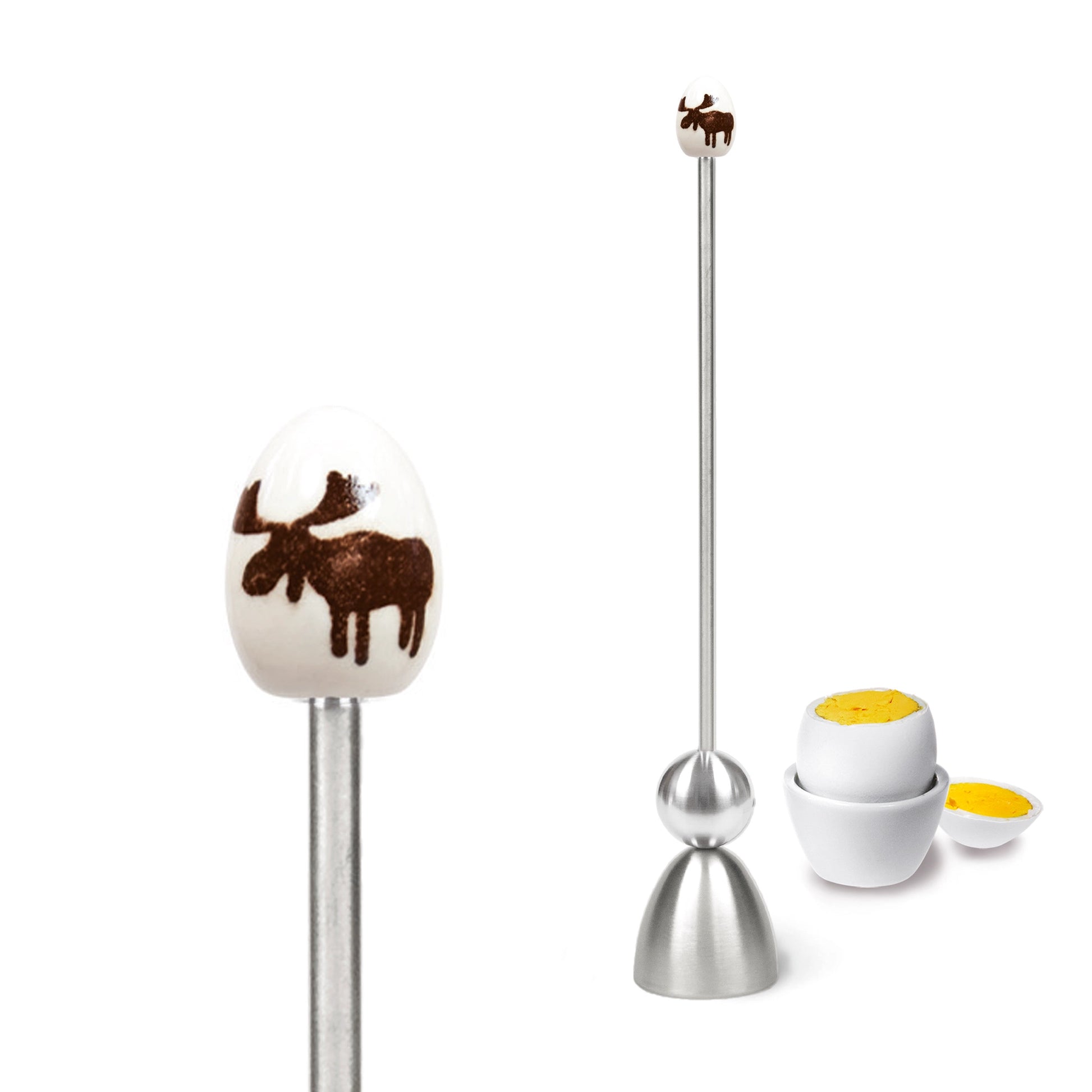 Clack egg topper with a ceramic egg with an elk, close up beside a boiled egg.
