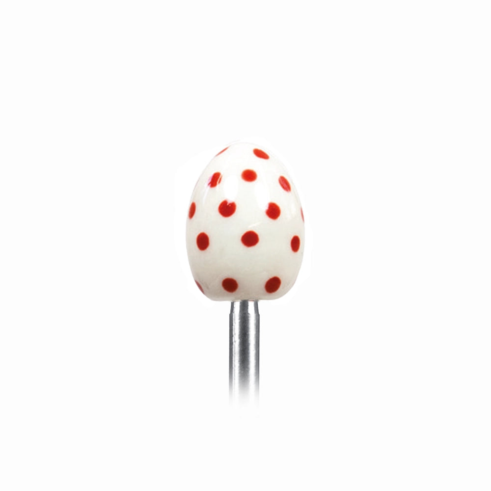 Clack egg topper with a ceramic egg with red spots, close up beside a boiled egg.