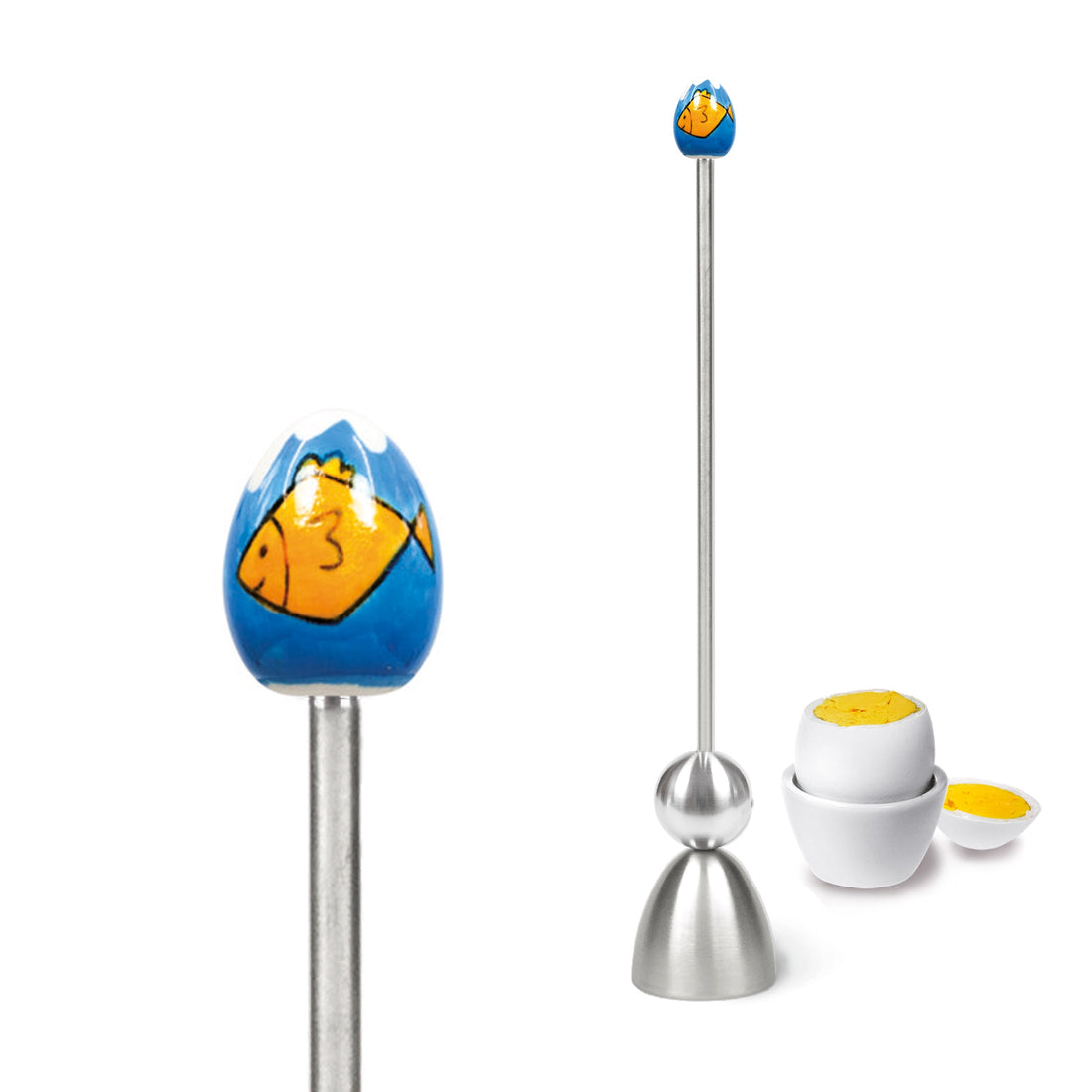 Clack egg topper with a ceramic egg with a fish, close up beside a boiled egg.