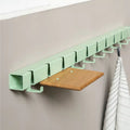Wandkapstok Coatrack by the Meter hangt tegen beige wand met eiek plankje en theedoek aan haakje