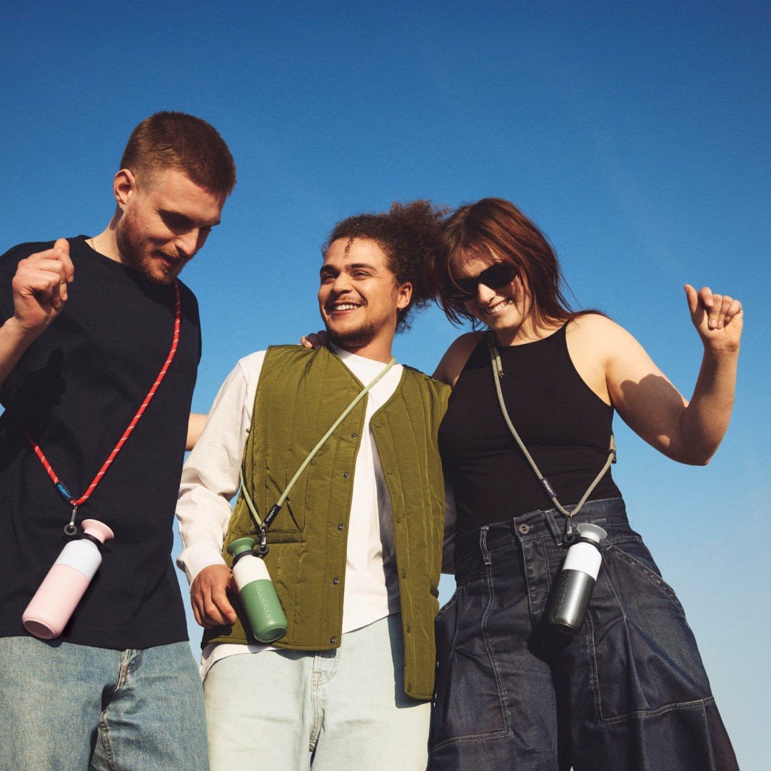 Dopper Cord 3 verschillende kleuren met fles ove schouder gedragen