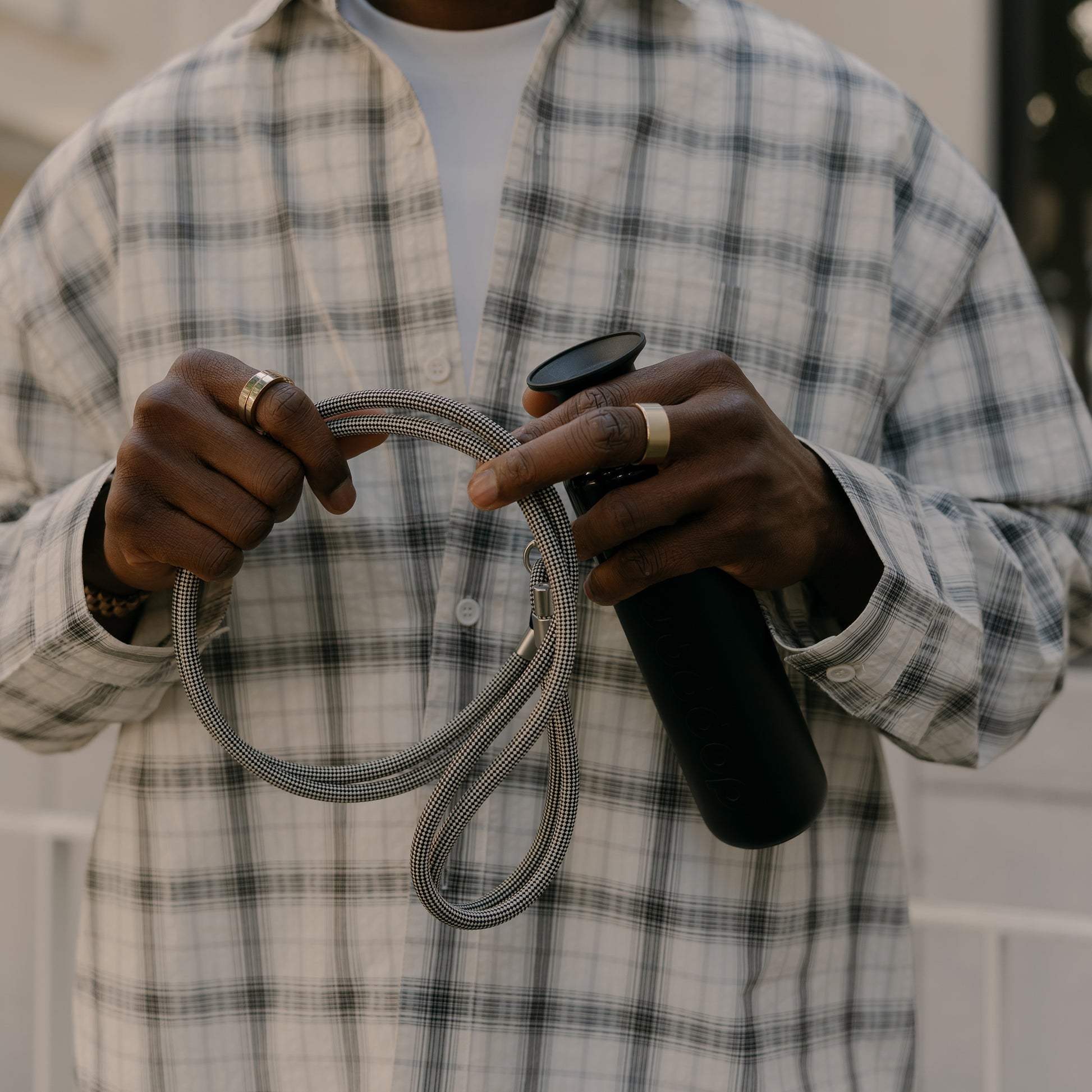 Dopper Cord Sandy Black│art. 7405│man houdt koord in hand met thermosfles