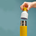 Dopper Insulated Small Lemon Crush│Thermosfles 350ml Geel│art. 4466│met beker in hand boven fles