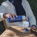 Dopper Insulated large Breaker Blue│Thermosfles 580ml Blauw│art. 3391│man schent water in beker op buitentafel