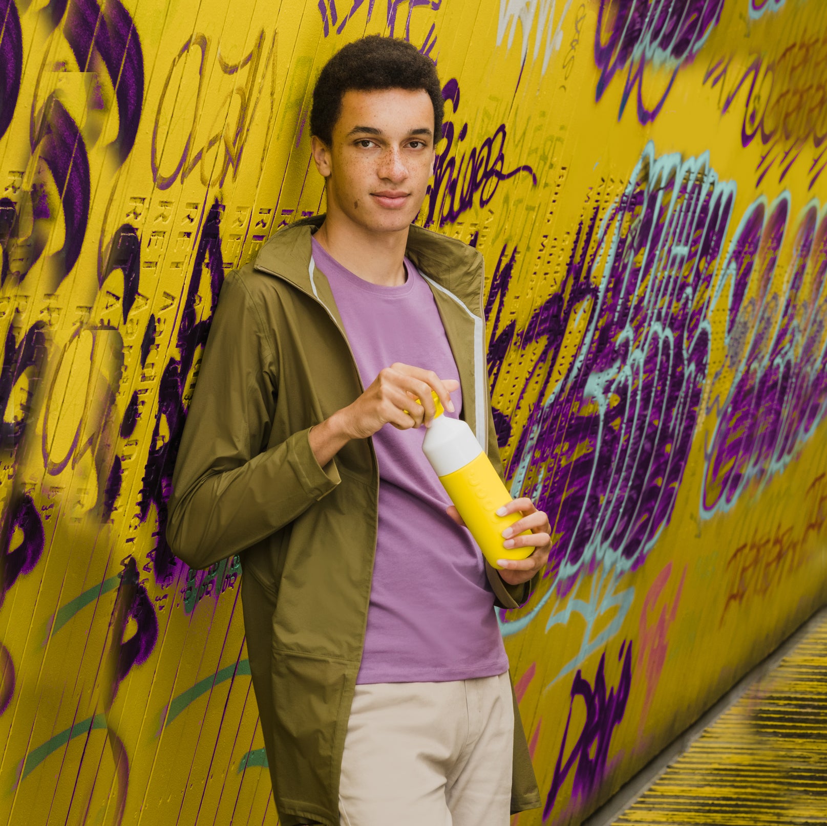 Dopper Insulated Lemon Crush│Thermosfles 580ml Geel│art. 4459│jongen naast graffiti wand met fles in hand