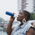 Dopper Original Cosmic Storm│Waterfles 450ml Blauw│art. 3810│vrouw drink water uit fles met std op achtergrond