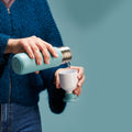 Dopper Insulated Small Bottlenose Blue│Thermosfles 350ml blauw│art. 5296│vrouw schenkt water in losse beker