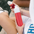 Dopper Insulated Small Deep Coral│Thermosfles 350ml Rood│art. 5272│aan waterkant met fles in hand