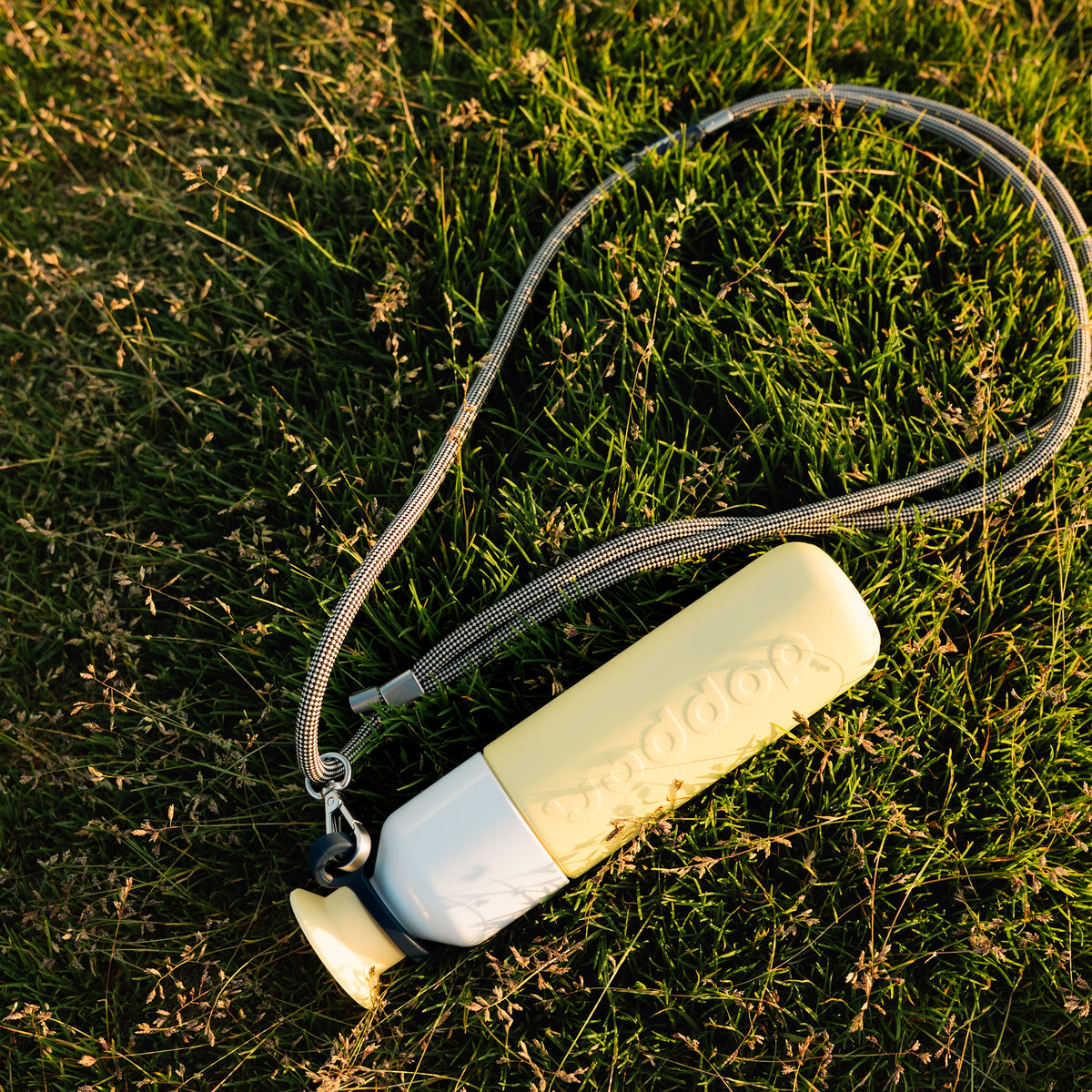 Insulated Bottle 350 ml Maple Yellow (yellow) - seen from above, lying in the grass on a cord