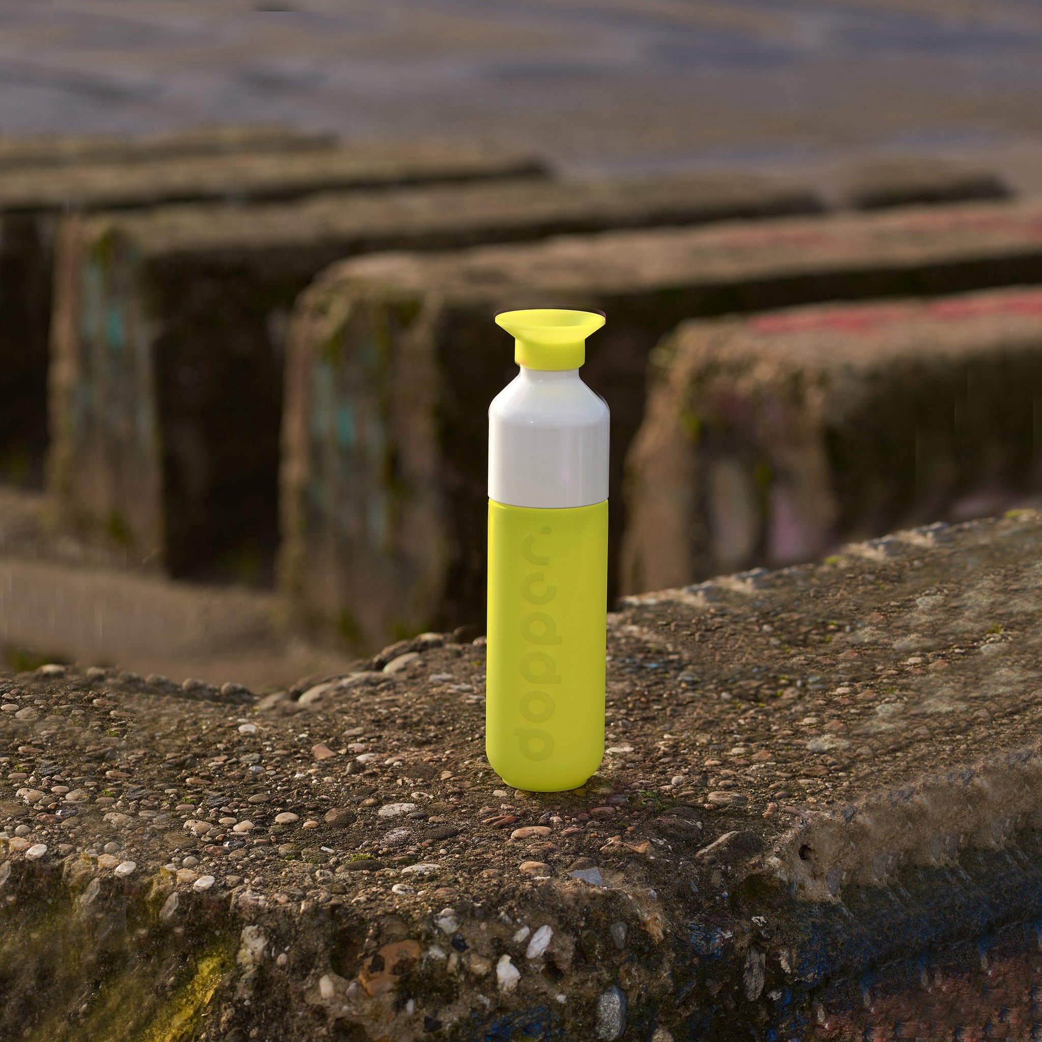 Dopper Original Seahorse Lime│Waterfles 450ml Geel│art. 5173│op betonnen ondergrond naast zee