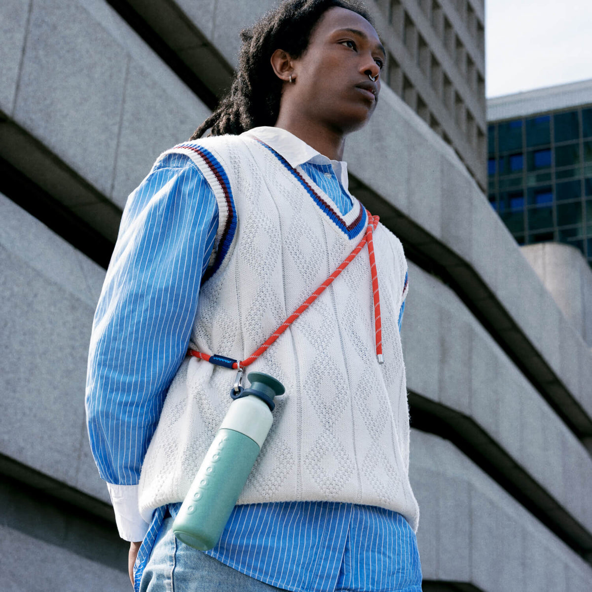 Steel Wasserflasche 490 ml Canopy Green (Grün) - an einem Band über der Schulter eines Mannes im Freien