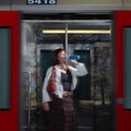 Steel Water Bottle 490 ml Coastal Blue (blue) - woman in a metro doorway drinking from the bottle