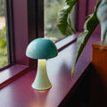 Remember Filou Wiederaufladbare LED-Tischleuchte | Hellblau | Art. LLM03 | auf einer lila Fensterbank, Licht an