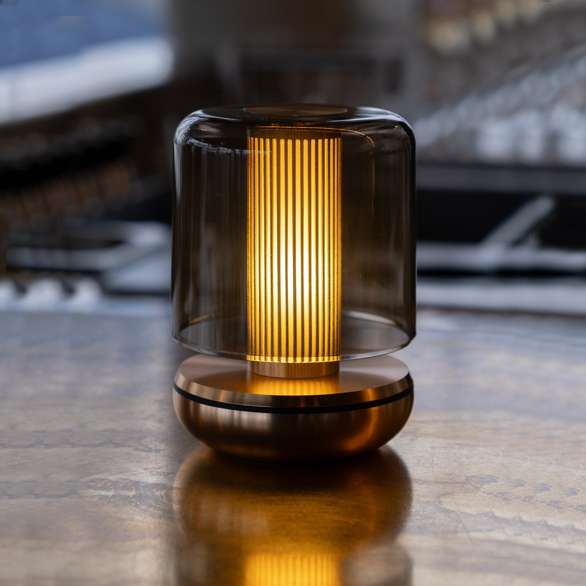 Humble Firefly Oplaadbare Tafellamp Bronze Smoked│art. HUMTL00404│op houten tafel met licht aan