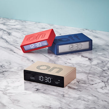 Verschillende Flip Wekkers van Lexon op een marmeren tafel.