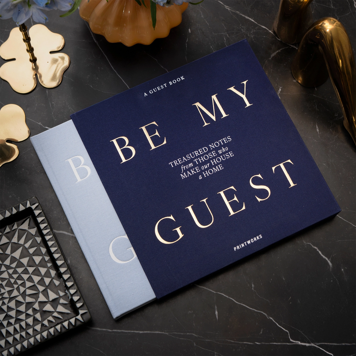 Hellblaues Gästebuch Be My Guest von Printworks auf einem schwarzen Marmortisch