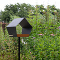 Big Diamond Vogelvoederhuis Donkergrijs van Heeej tussen bloemen en planten in tuin