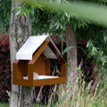 The Barn Design Birdfeeder van Heeej hangt aan boom met vetbol in schaaltje