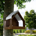Aanzicht schuin onder van Birdfeeder the Barn in Bruin en Wit aan een boom in moderne tuin