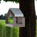 Zijaanzicht schuin van Vogelvoederhuisje The Barn Beige tegen boom met gras op achtergrond