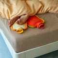 Warmwaterkruik Katoen Bumper Poppy Orange│Suite702│art. BHWBPO│met mini versie op bed met blote voeten 