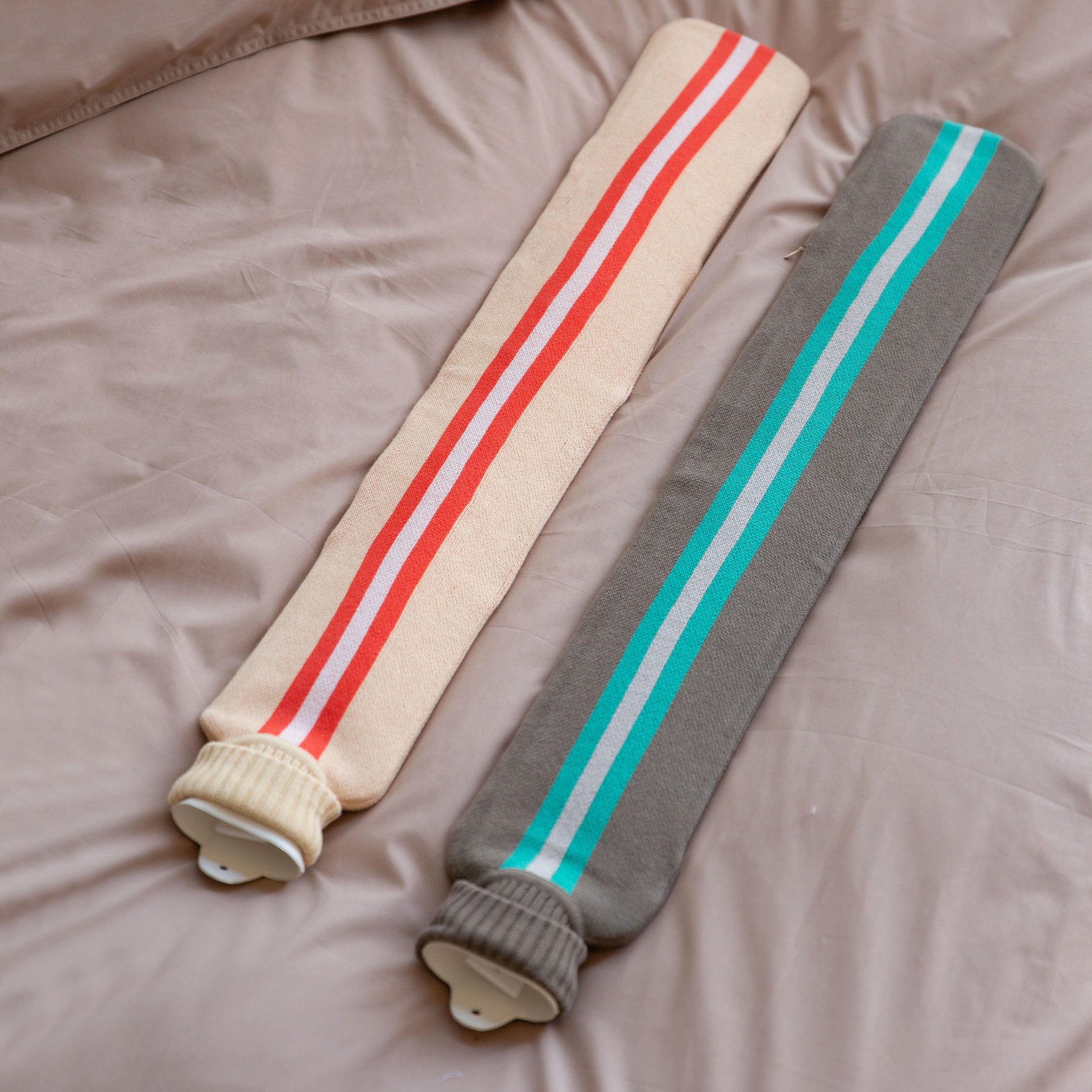 Warmwaterkruik XL van Suite 702 in de kleuren Taupe en Peach liggen naast elkaar op bed