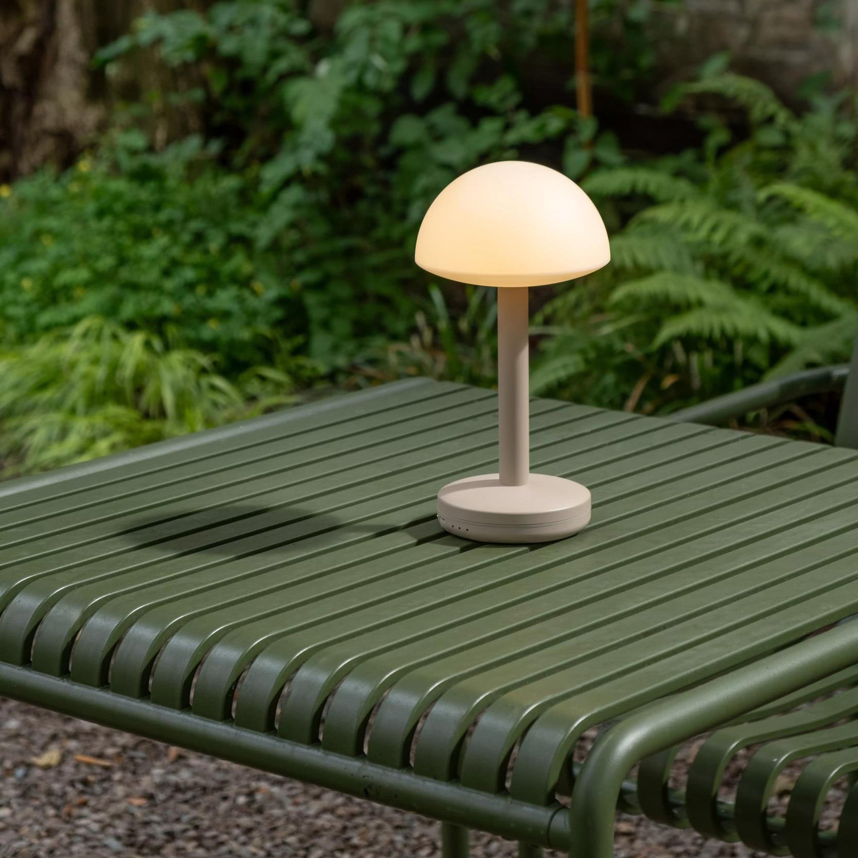 Humble Bug Oplaadbare tafellamp Frosted Beige│voorkant met witte achtergrond│art. HUMTL00305op groen buitentafel met licht aan
