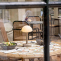 Humble Bug Oplaadbare tafellamp Frosted Beige│Op ronde tafel in restaurant│art. HUMTL00305