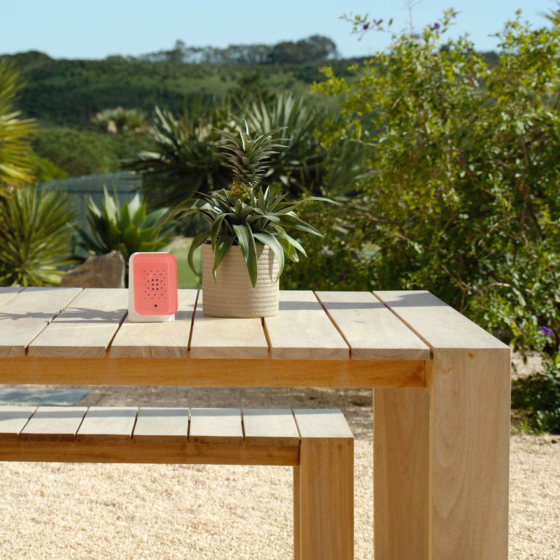 Junglebox Rosy Relaxound│Oerwoudgeluiden│art. 11JGL0101002│op houten buitentafel met tuin op achtergrond