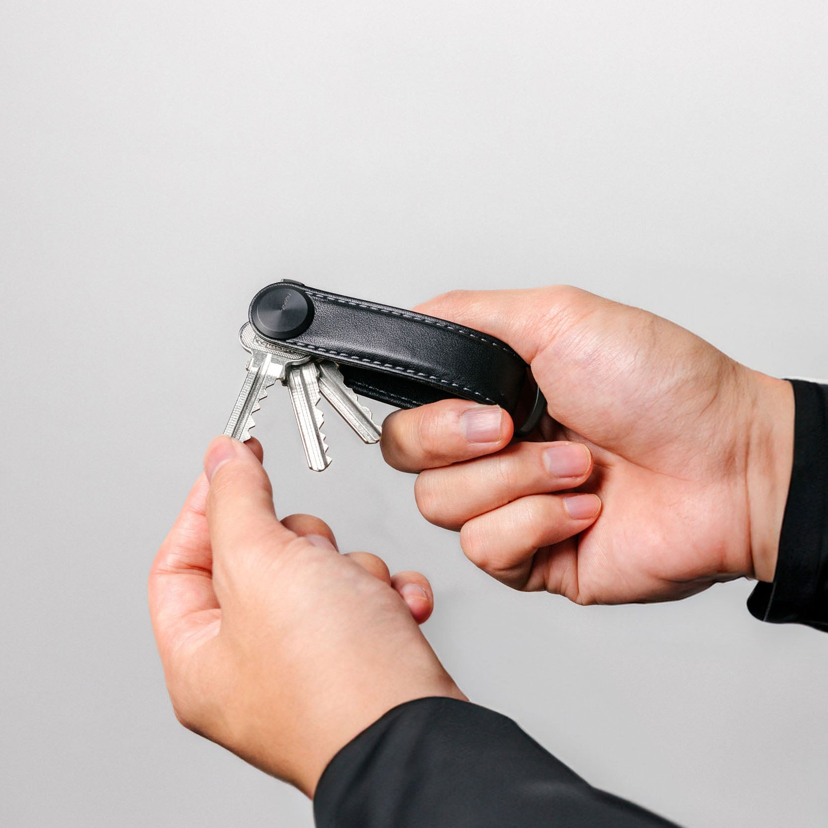 Orbitkey Sleutelhouder Pro Blackout│Key Organiser│art. KPR1-BKT-101│in handen van man met uitgevouwen sleutels