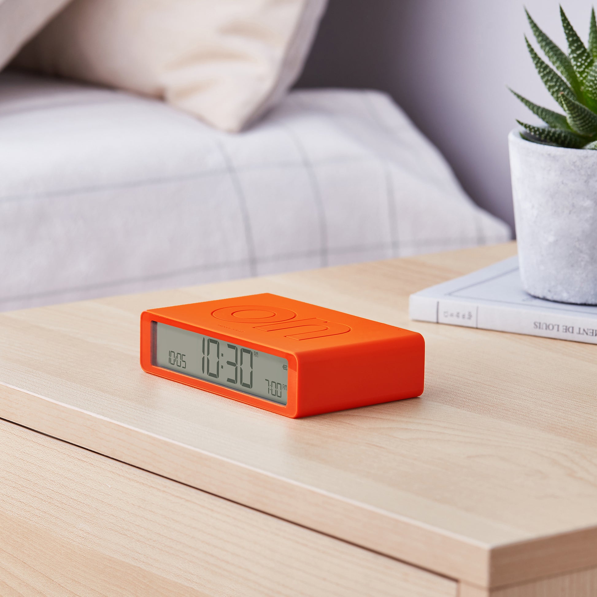 Lexon Flip+ Wekker Digitaal Oranje│art. LR157O4│op nachtkastje met On-teken boven