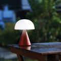 Lexon Mina Large Oplaadbare Tafellamp Donkerrood│art. LH65DR│op terrastafel in regen