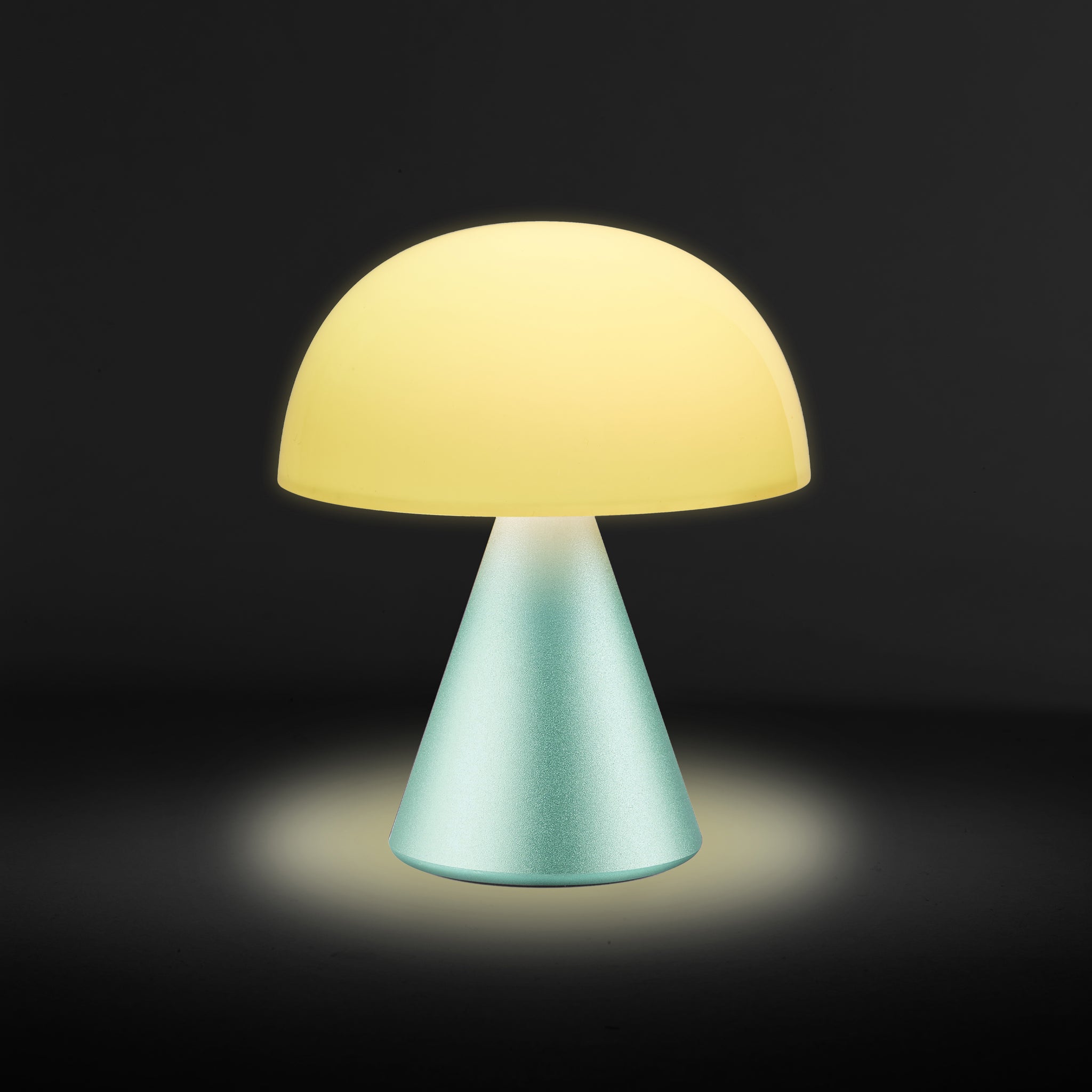 Lexon Mina Medium Mint Groen│LH64M1│Oplaadbare LED-Lamp│geel licht aan tegen donkere achtergrond