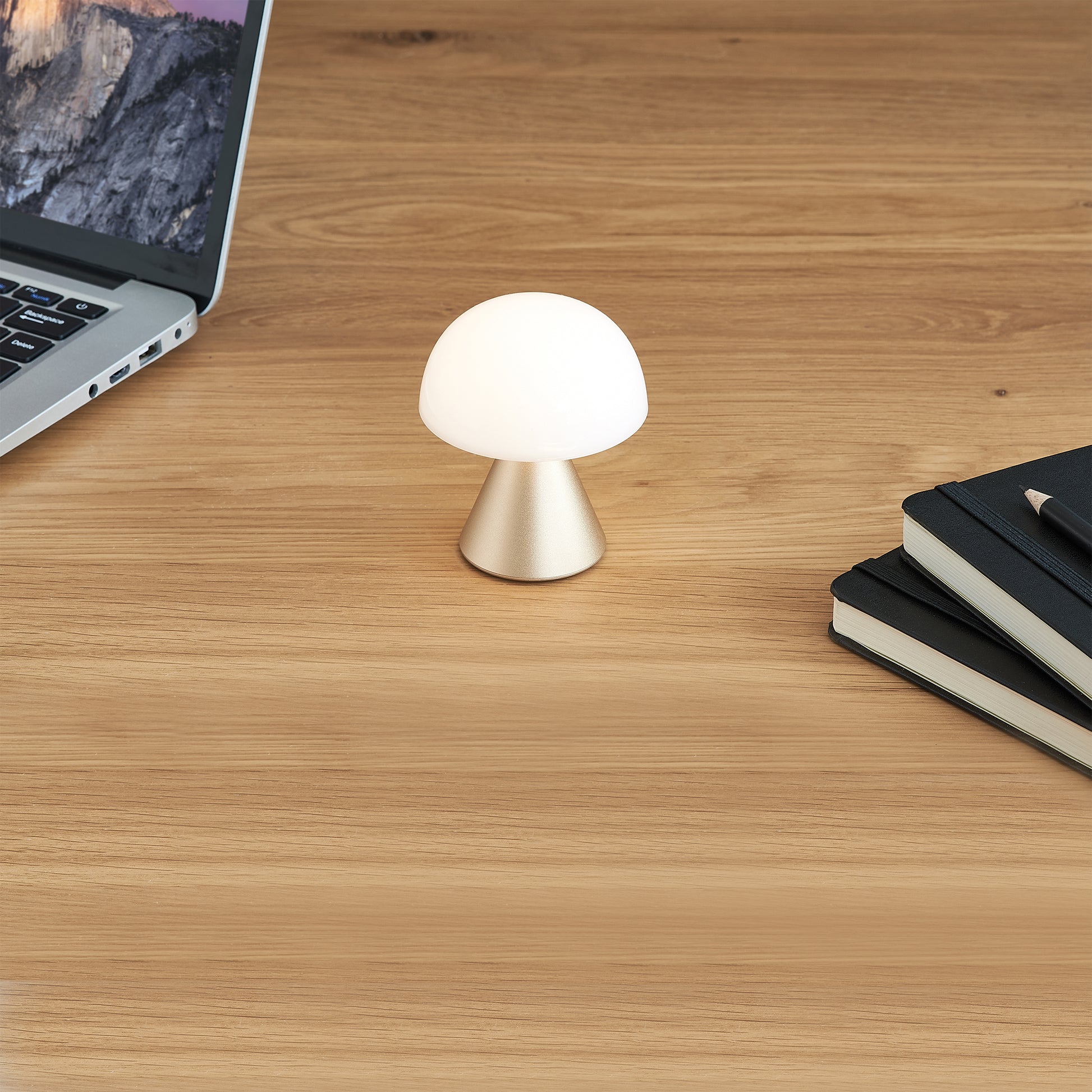 Lexon Mina Small Soft Gold│Oplaadbare LED lamp│art. LH60MD│op bureau naast laptop