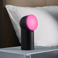Lexon Orbe Zwart│Oplaadbare Tafellamp│art. LH88N│op nachtkastje met roze licht aan