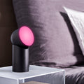 Lexon Orbe Zwart│Oplaadbare Tafellamp│art. LH88N│op nachtkastje met roze licht naar boven gericht