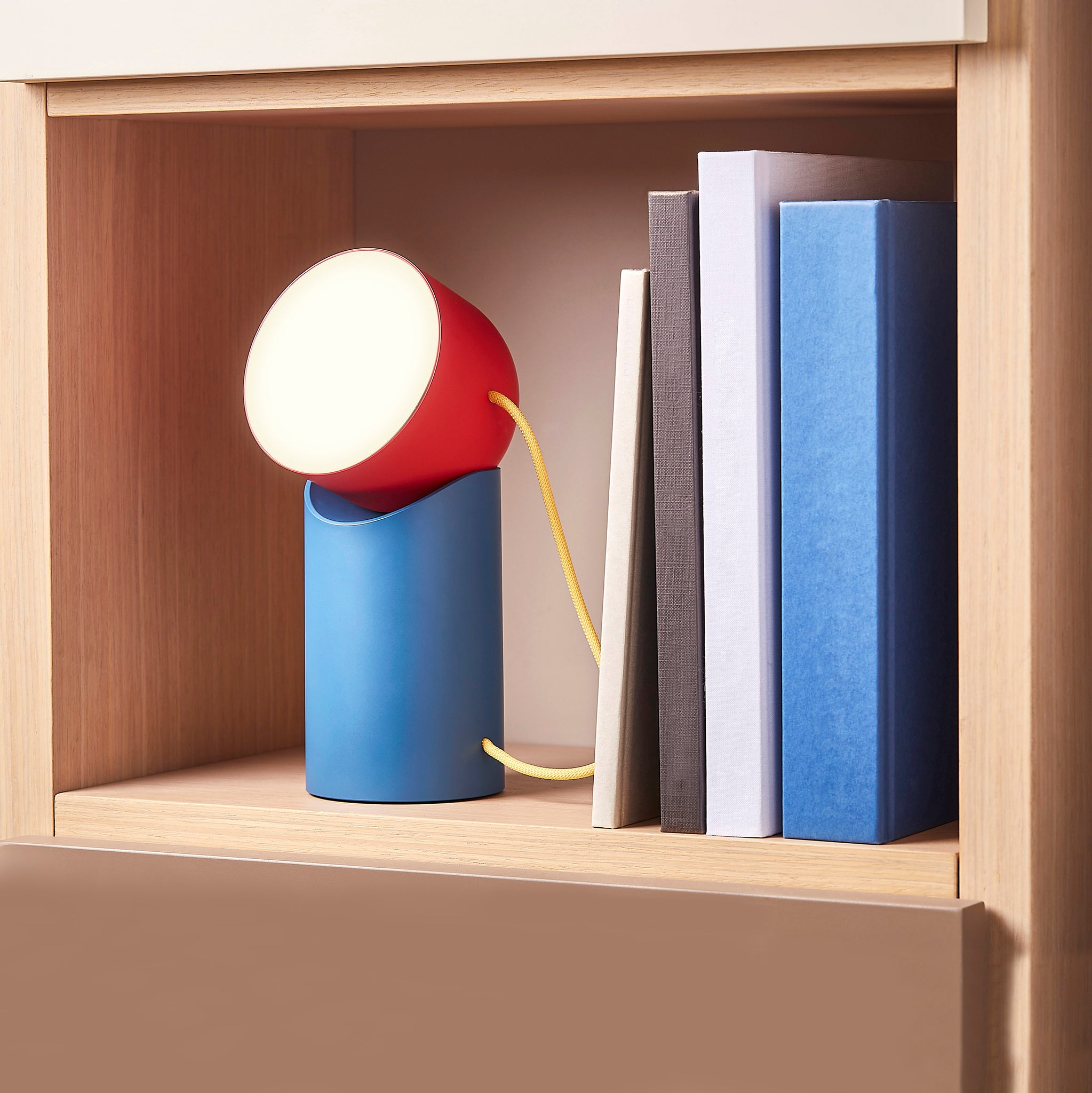 Lexon Orbe Duck Blue&Red│Oplaadbare Tafellamp│art. LH88DRY│in beokenkast met warm licht aan