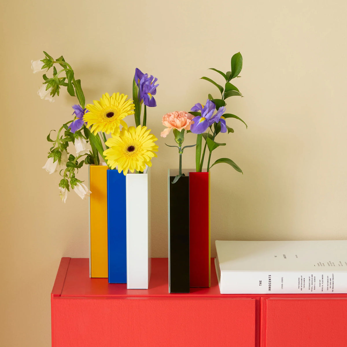 twee delen naast elkaar me kleuren naar buiten met bloemen op rood dressoir