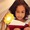 Little Sun Original│Lampje op Zonne-energie│Olufar Eliasson│in hand van meisje met boek