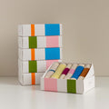 Gastendoekjes Martens & Martens Gift Set van 6 stuks in geopende doos met stapel dozen erachter 