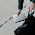 Man stopt Memobottle Platte Waterfles RVS satin in zwarte tas.