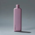 Memobottle Slim flat stainless steel water bottle in pink, front view with a shadow on a grey background.
