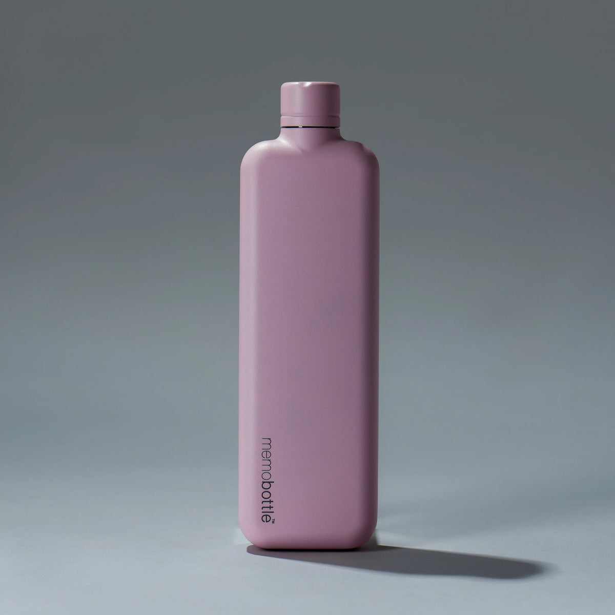 Memobottle Slim flat stainless steel water bottle in pink, front view with a shadow on a grey background.