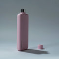 Memobottle Slim flat stainless steel water bottle in pink, angled side view with the lid beside the bottle.