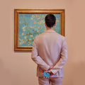 Secrid Miniwallet Art Collection│art. MAR-ALMOND BLOSSOM│man voor schilderij met portemonnee in handen op zijn rug
