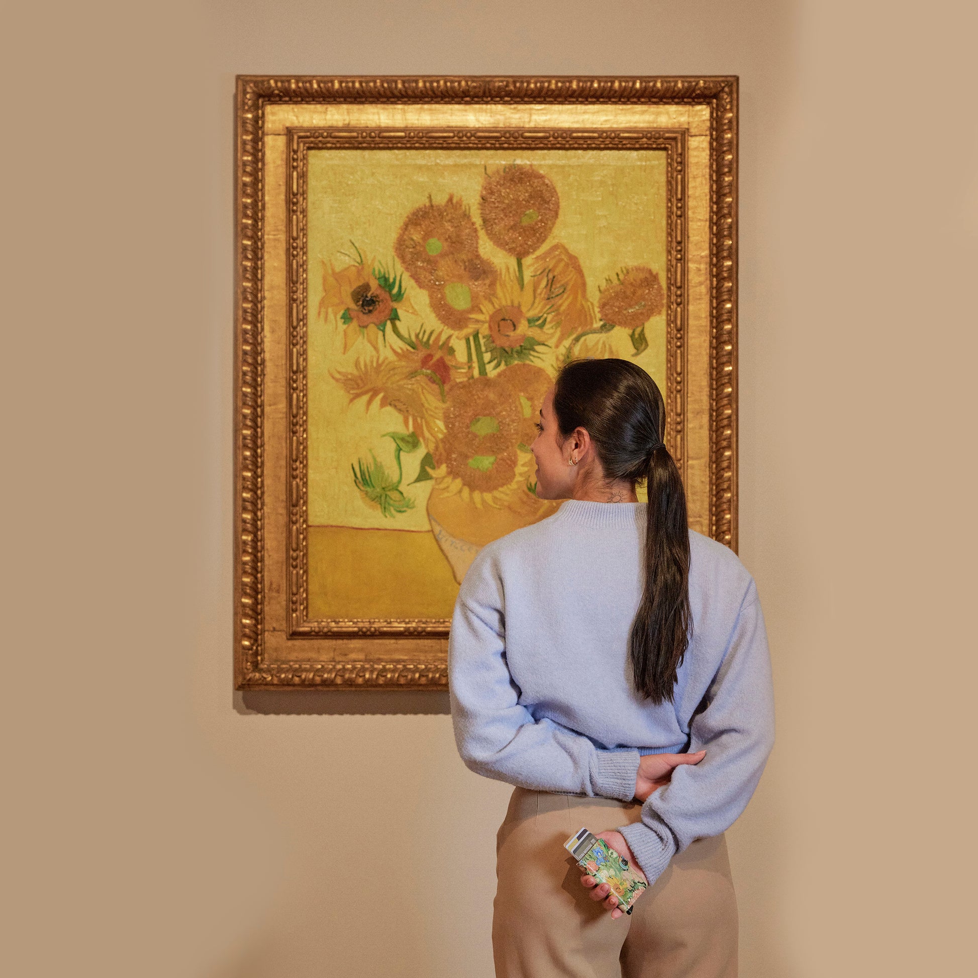 Secrid Miniwallet Art Collection│art. MAR-BOUQUET│vrouw voor zonnebloemen met portemonnee in hand