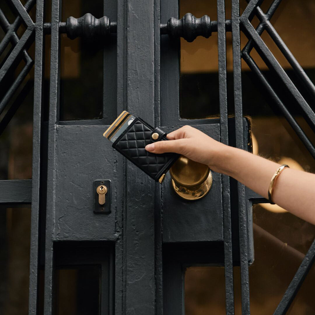 Secrid Miniwallet Emboss Diamond│art. MED-BLACK│in hand vastgehouden voor ijzeren poort