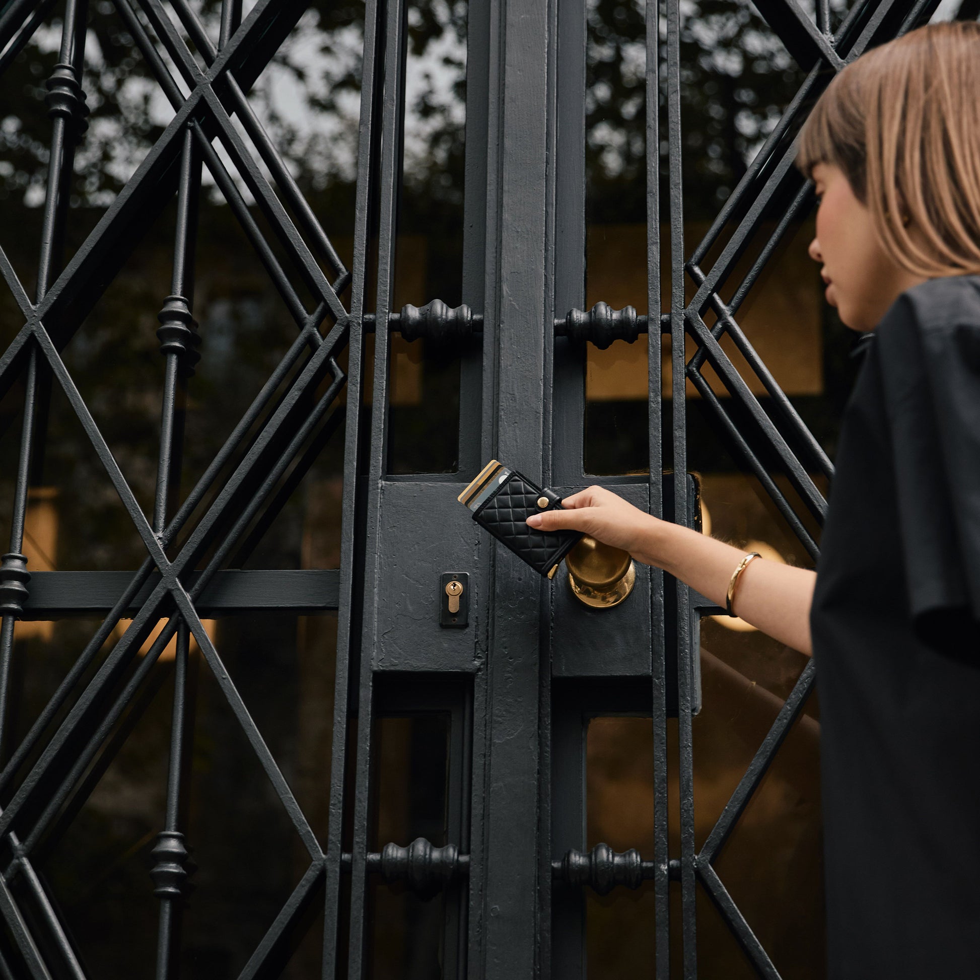 Secrid Miniwallet Emboss Diamond│art. MED-BLACK│vrouw met portemonnee voor ijzeren deur