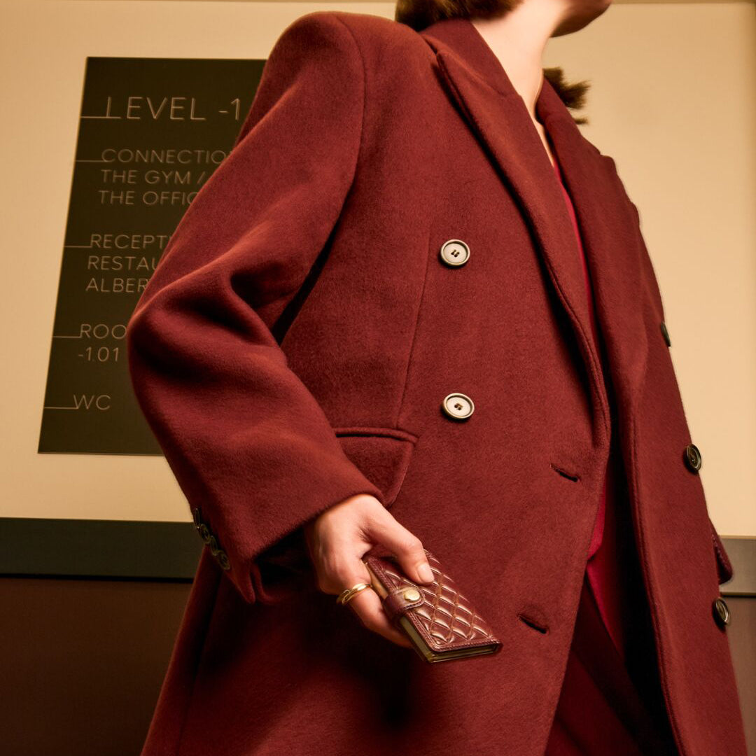 Secrid Miniwallet Emboss Diamond│art. MED-BORDEAUX│in hand van vrouw met donkerrode jas