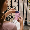 Secrid Miniwallet Emboss Diamond│art. MED-ROSE│in hand van vrouw voor ijzeren hek